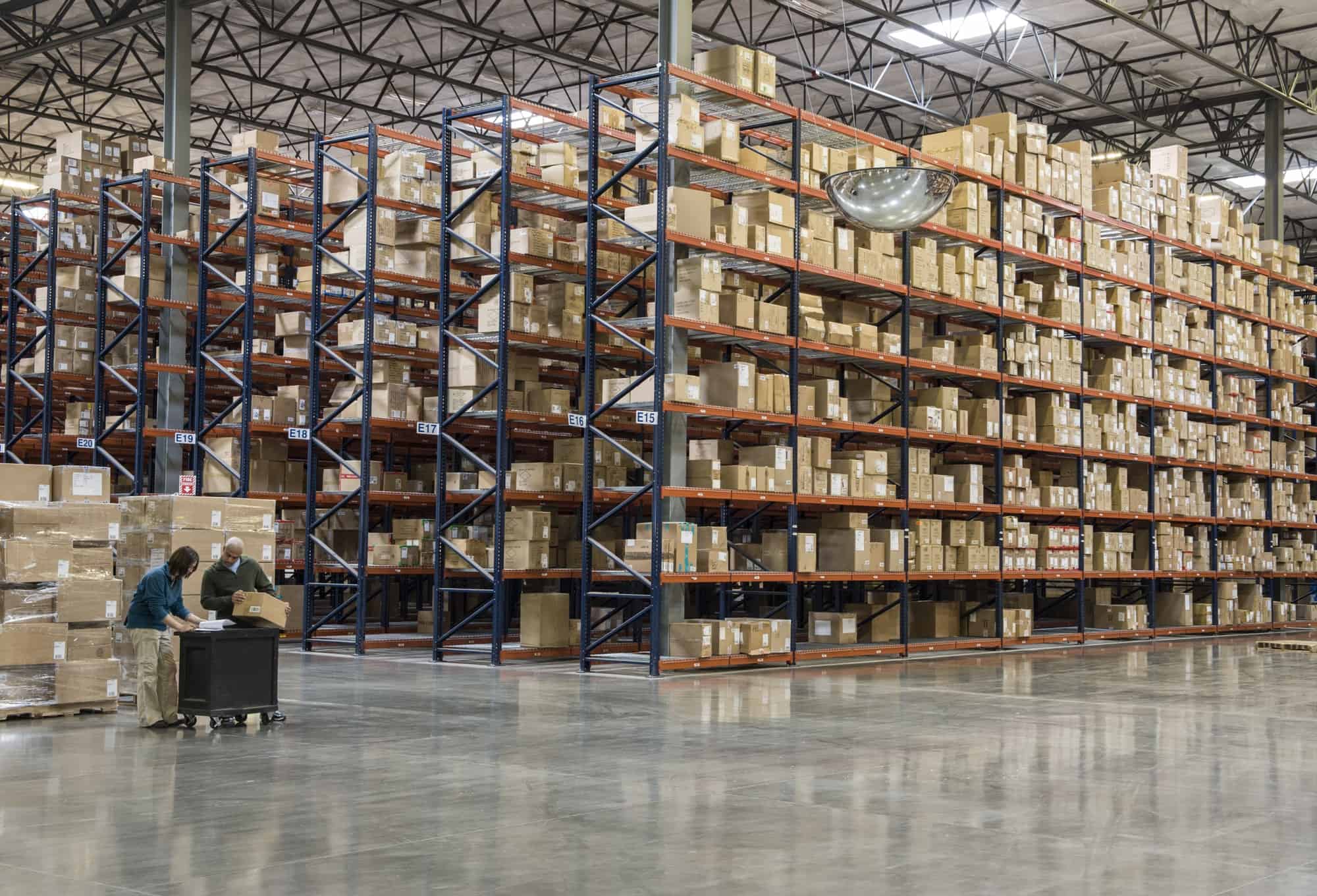Two employees checking inventory in temporary storage in a distribution warehouse.